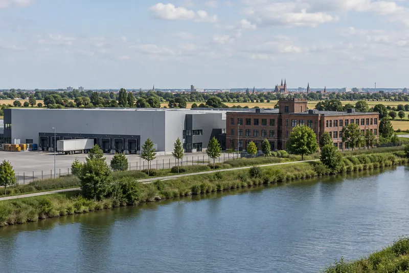 Gewerbehalle und Bürogebäude am Mittellandkanal bei Braunschweig, im Hintergrund die Türme der Altstadt