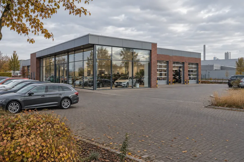 Autohaus mit Verkaufsraum und Werkstatt am Stadtrand von Braunschweig, im Hintergrund niedrige Gewerbehallen