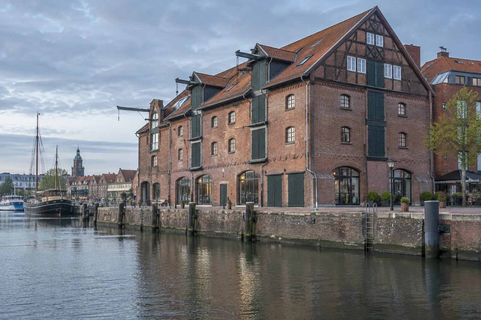 Historischer Backsteinspeicher mit Fachwerkgeschoss an einem Hafenbecken in Emden