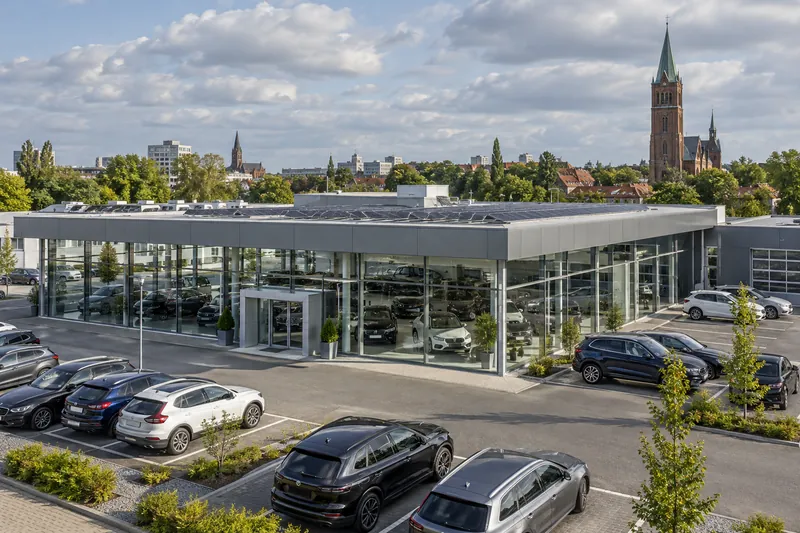 Saniertes Autohaus mit Glasfassade und Photovoltaik auf dem Flachdach in einem Gewerbegebiet in Braunschweig