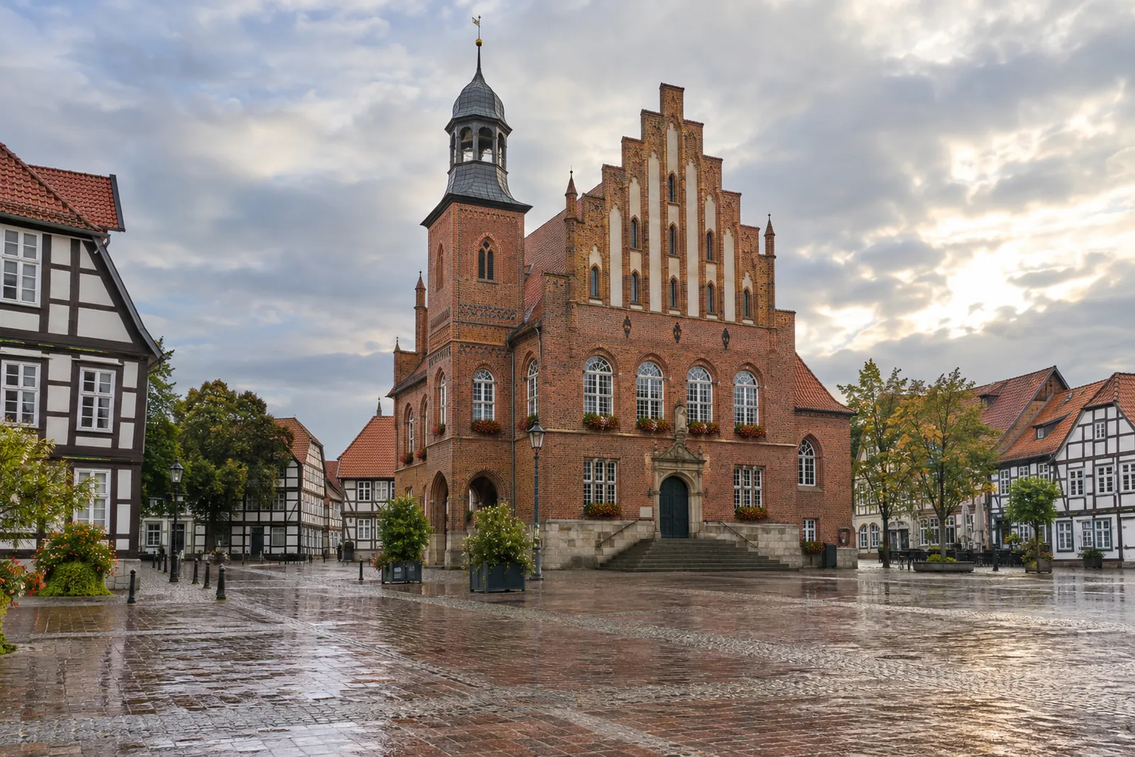 Backsteinrathaus mit Treppengiebel und kleinem Turm an einem Marktplatz in Niedersachsen, daneben Fachwerkhäuser