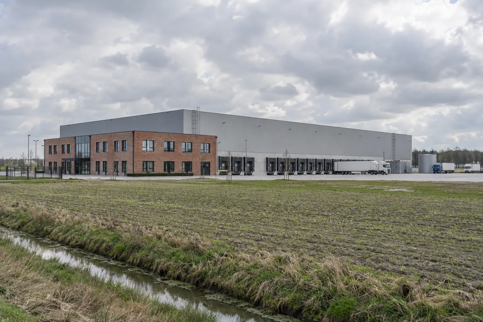 Kühllager mit Backsteinanbau und Laderampen auf flachem Land bei Vechta in Niedersachsen