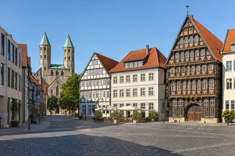 Rekonstruierte Fachwerkhäuser am Marktplatz in Hildesheim mit Geschäftsgebäuden und Kirchtürmen im Hintergrund
