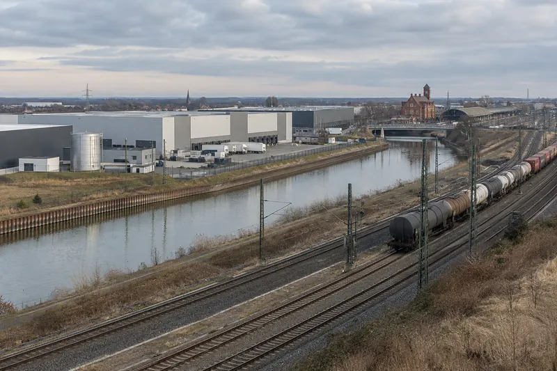 Logistikhallen und Gewerbebauten am Mittellandkanal bei Lehrte mit Bahngleisen im Vordergrund