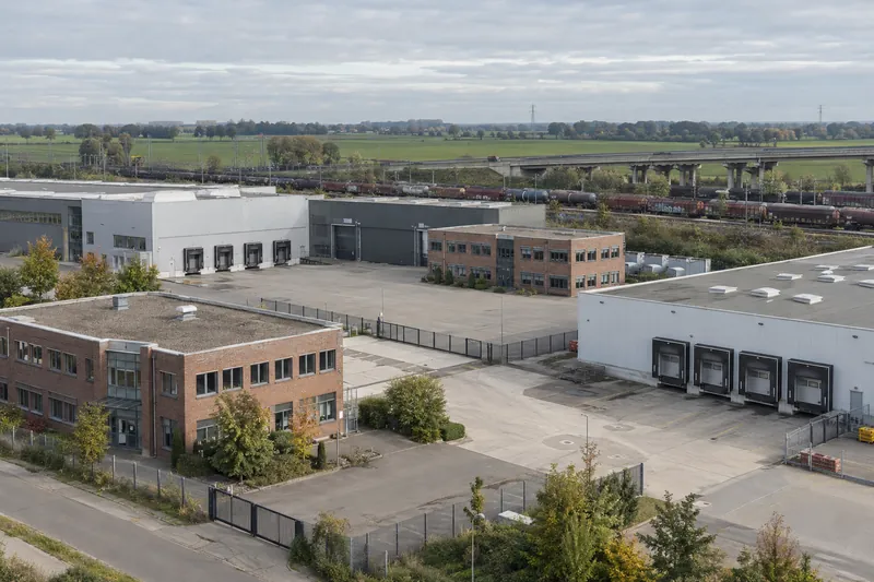 Gewerbehallen mit Bürotrakt nahe Autobahn und Güterbahn im Süden von Hamburg, flache Marschlandschaft